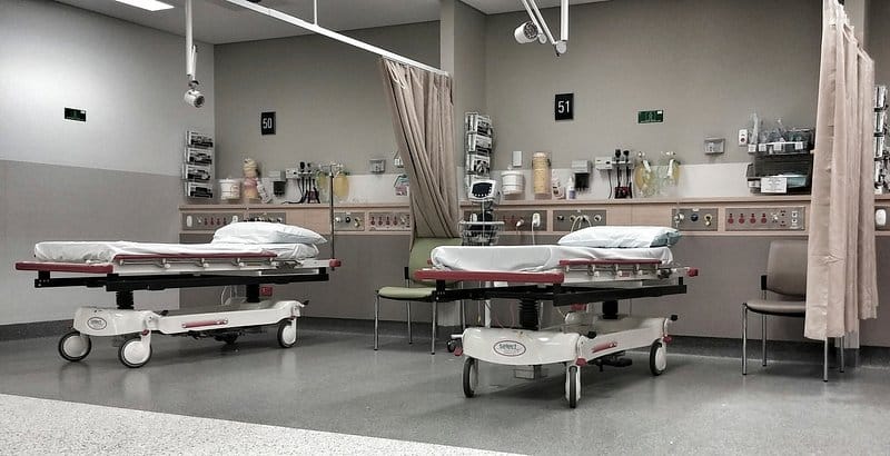 Inpatient bay with hospital beds, privacy curtains and wall-mounted medical gas panels